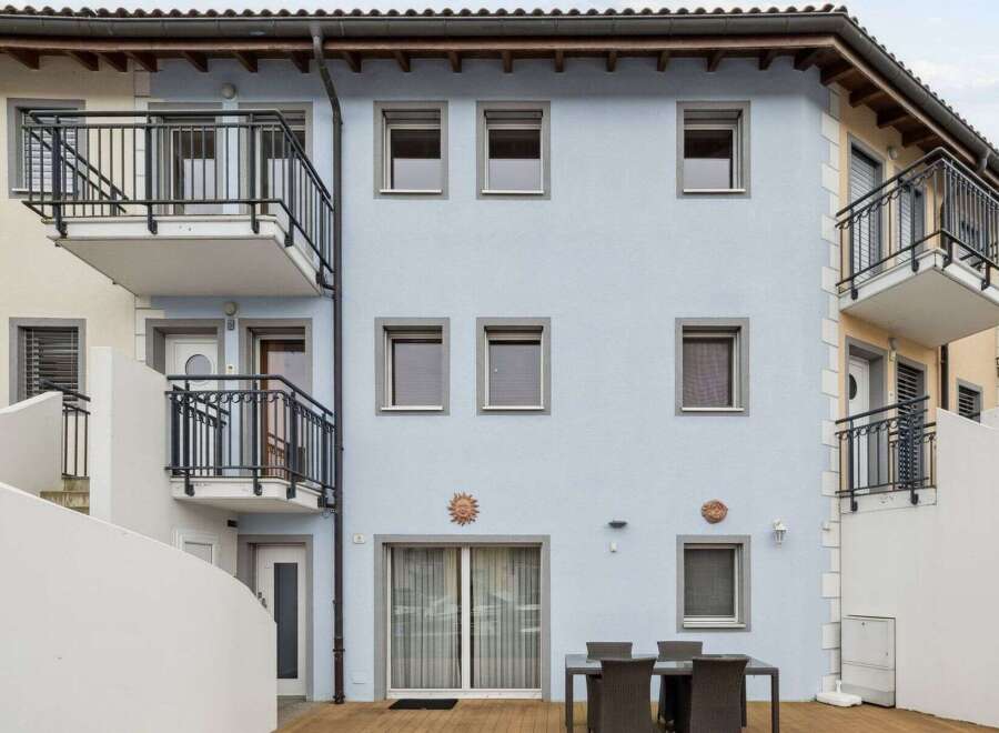 Discover this charming property featuring a light blue facade, complemented by balconies and stylish windows.