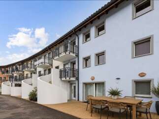 Discover modern living in this stunning property featuring stylish balconies and a welcoming outdoor dining area.