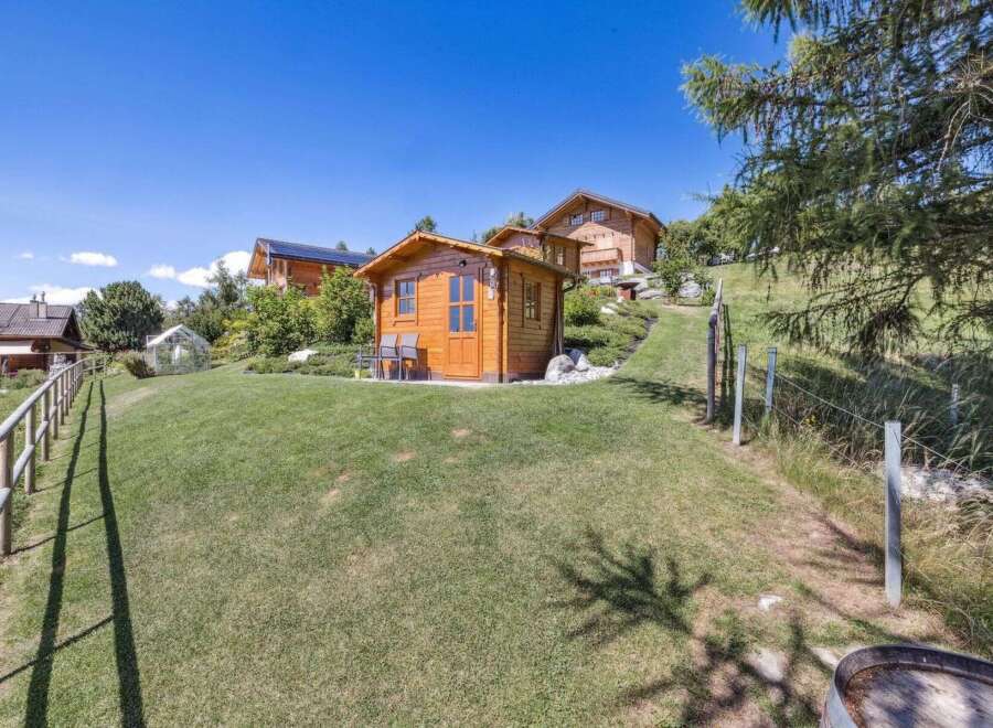 Discover a charming wooden cabin nestled in a serene, green landscape, perfect for a peaceful retreat.