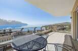 Enjoy breathtaking views from this stunning property! This home features a spacious balcony with a stylish metal table and chairs, perfect for relaxing and entertaining.