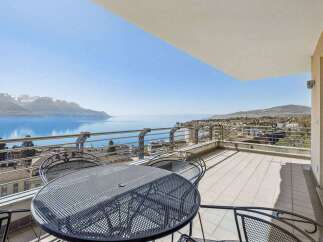 Enjoy breathtaking views from this stunning property! This home features a spacious balcony with a stylish metal table and chairs, perfect for relaxing and entertaining.