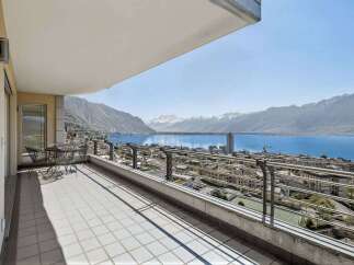 Enjoy breathtaking views from this stunning balcony overlooking the serene lake and majestic mountains.