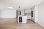 This modern kitchen boasts sleek, minimalist design with high-end appliances and ample storage.