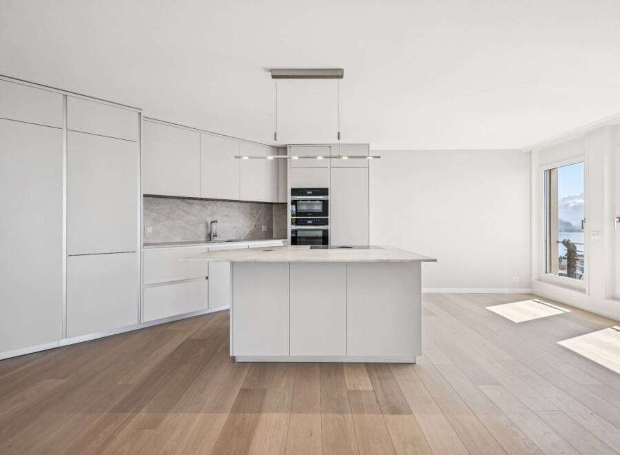 Experience modern luxury in this stunning kitchen! Featuring sleek, white cabinetry, a spacious island, and high-end appliances, this space is perfect for both cooking and entertaining.