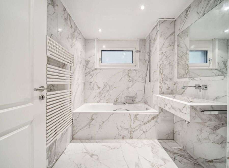 This luxurious bathroom boasts stunning marble finishes throughout, creating a spa-like ambiance.