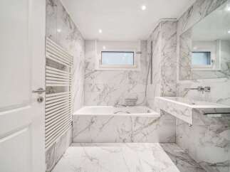 This luxurious bathroom boasts stunning marble finishes throughout, creating a spa-like ambiance.
