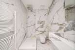 This luxurious bathroom boasts stunning marble finishes throughout, creating a spa-like ambiance.