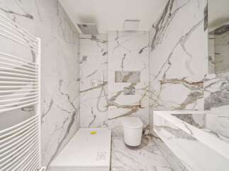 This luxurious bathroom boasts stunning marble finishes throughout, creating a spa-like ambiance.