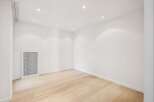 This bright and airy room features a modern design with clean white walls and a light wood floor.