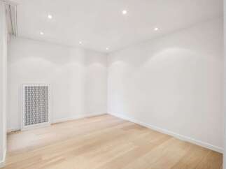 This bright and airy room features a modern design with clean white walls and a light wood floor.