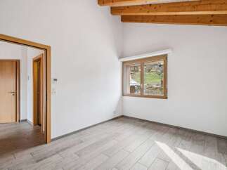 Discover this bright and airy room, featuring a modern design with light-colored wooden floors and pristine white walls.