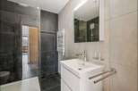 This modern bathroom features sleek gray tiles and a minimalist design.