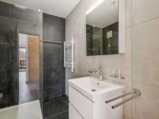 This modern bathroom features sleek gray tiles and a minimalist design.