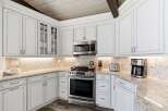 This stunning kitchen boasts elegant white cabinetry with intricate detailing, complemented by a beautiful marble countertop.