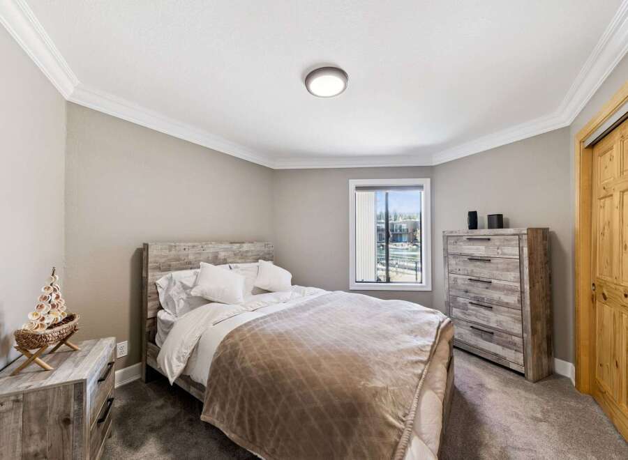 Step into this inviting bedroom, featuring a cozy bed with a stylish headboard and a warm, neutral color palette.