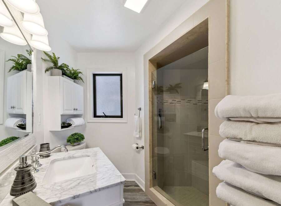 Step into luxury with this stunning bathroom! Featuring a sleek marble countertop, a modern glass shower, and ample storage, this space is designed for both style and functionality.