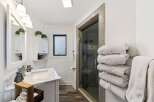 Step into this beautifully designed bathroom, featuring a modern vanity with a marble countertop and a sleek sink.