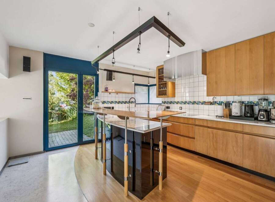This stunning kitchen boasts a modern design with sleek cabinetry and a unique island.