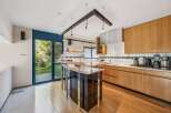 This stunning kitchen boasts a modern design with sleek cabinetry and a unique island.