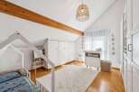 This charming nursery features a cozy house-shaped bed, a plush rug, and a stylish changing table.