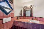 Step into this unique bathroom featuring a striking pink tiled design.
