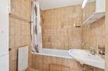 This bathroom features a classic design with warm-toned tiles, creating a cozy atmosphere.