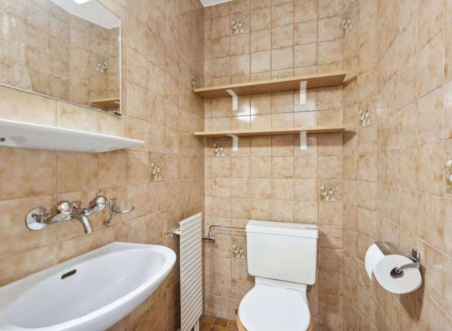 This charming bathroom features a classic design with tiled walls and a functional layout.