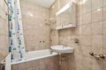 This bathroom features a classic design with tiled walls and a bathtub.