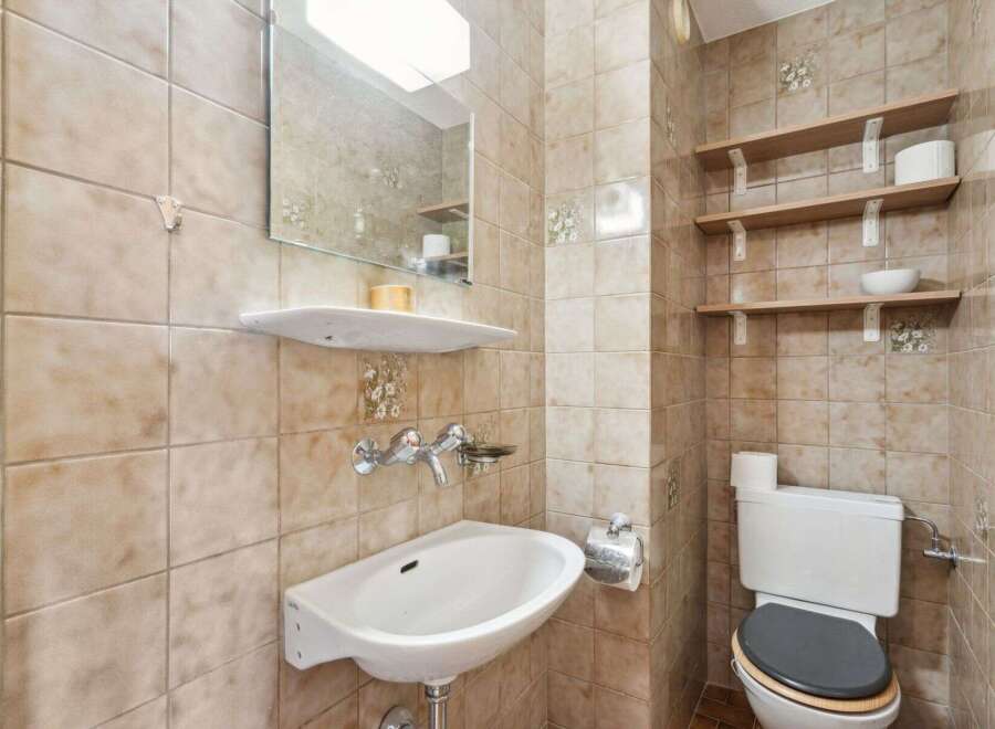 This charming bathroom features a classic design with tiled walls and a functional layout.
