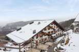 Nestled in a snowy landscape, this charming property boasts a traditional chalet design with a steeply pitched roof.