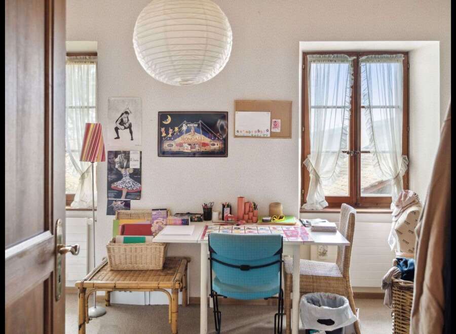 This charming room offers a bright and inviting space, perfect for a home office or creative studio.