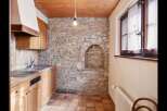 This charming kitchen features a rustic stone wall, adding character and warmth to the space.