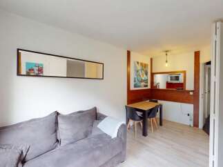Discover this cozy apartment featuring a comfortable gray sofa, perfect for relaxing.