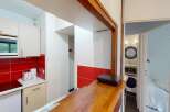 Discover this charming property featuring a well-equipped kitchen with modern appliances and a stylish red tile backsplash.