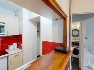 Discover this charming property featuring a well-equipped kitchen with modern appliances and a stylish red tile backsplash.