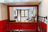 Discover this charming property featuring a well-equipped kitchen with a stylish red tile backsplash and a convenient pass-through window.