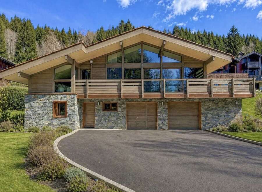 This stunning property boasts a unique architectural design with a blend of wood and stone elements, creating a warm and inviting atmosphere.