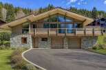 This stunning property boasts a unique architectural design with a blend of wood and stone elements, creating a warm and inviting atmosphere.