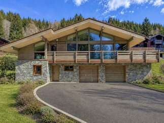 This stunning property boasts a unique architectural design with a blend of wood and stone elements, creating a warm and inviting atmosphere.