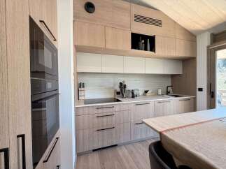 This modern kitchen boasts sleek, light wood cabinetry and a minimalist design, perfect for contemporary living.