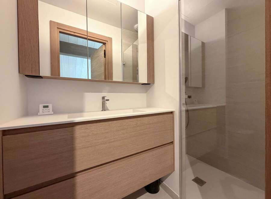This modern bathroom features a sleek vanity with ample storage and a stylish design.
