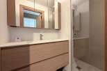 This modern bathroom features a sleek vanity with ample storage and a stylish design.