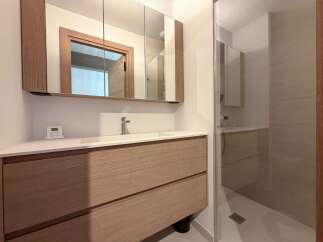 This modern bathroom features a sleek vanity with ample storage and a stylish design.