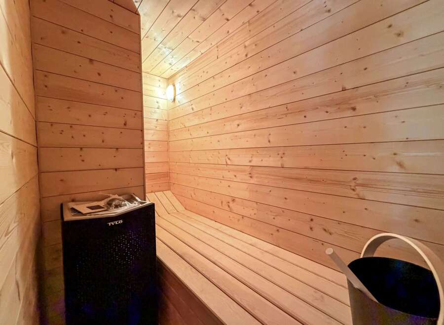 Step into your own private oasis with this stunning sauna! Featuring beautiful wood paneling and a comfortable bench, this space is perfect for relaxation and rejuvenation.