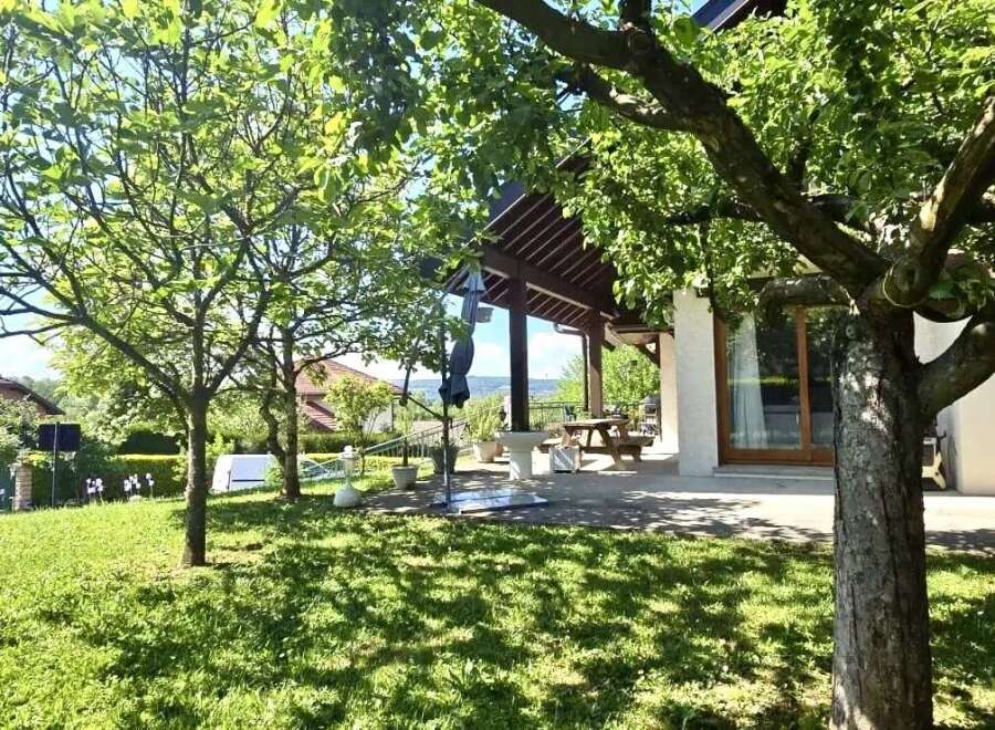 Discover this charming property featuring a lush green lawn and mature trees, creating a serene outdoor space.