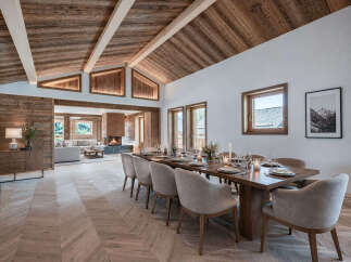 Experience luxury living in this stunning property featuring a beautifully designed dining area with a large wooden table and comfortable seating.
