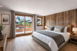 Experience luxury living in this stunning bedroom featuring a rustic wooden accent wall and a cozy ambiance.