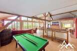Experience luxury living in this stunning property featuring a spacious interior with a pool table, perfect for entertainment.