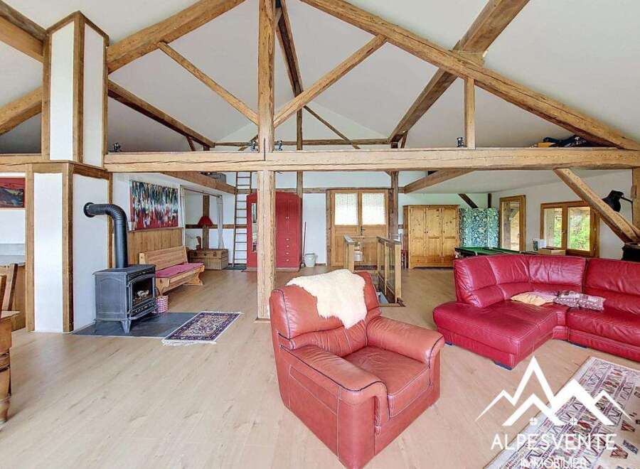 Discover the charm of this stunning property, featuring a spacious living area with exposed wooden beams and a cozy fireplace.