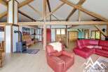 Discover the charm of this stunning property, featuring a spacious living area with exposed wooden beams and a cozy fireplace.